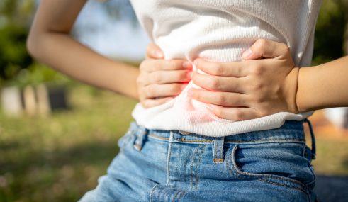 Femme avec les mains sur le ventre, symbole des troubles digestifs pris en charge par un gastro-entérologue Femme avec les mains sur le ventre, symbole des troubles digestifs pris en charge par un gastro-entérologue