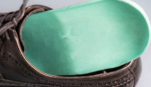 Semelle orthopédique insérée dans une chaussure, illustrant l’importance des dispositifs médicaux adaptés Semelle orthopédique insérée dans une chaussure, illustrant l'importance des dispositifs médicaux adaptés
